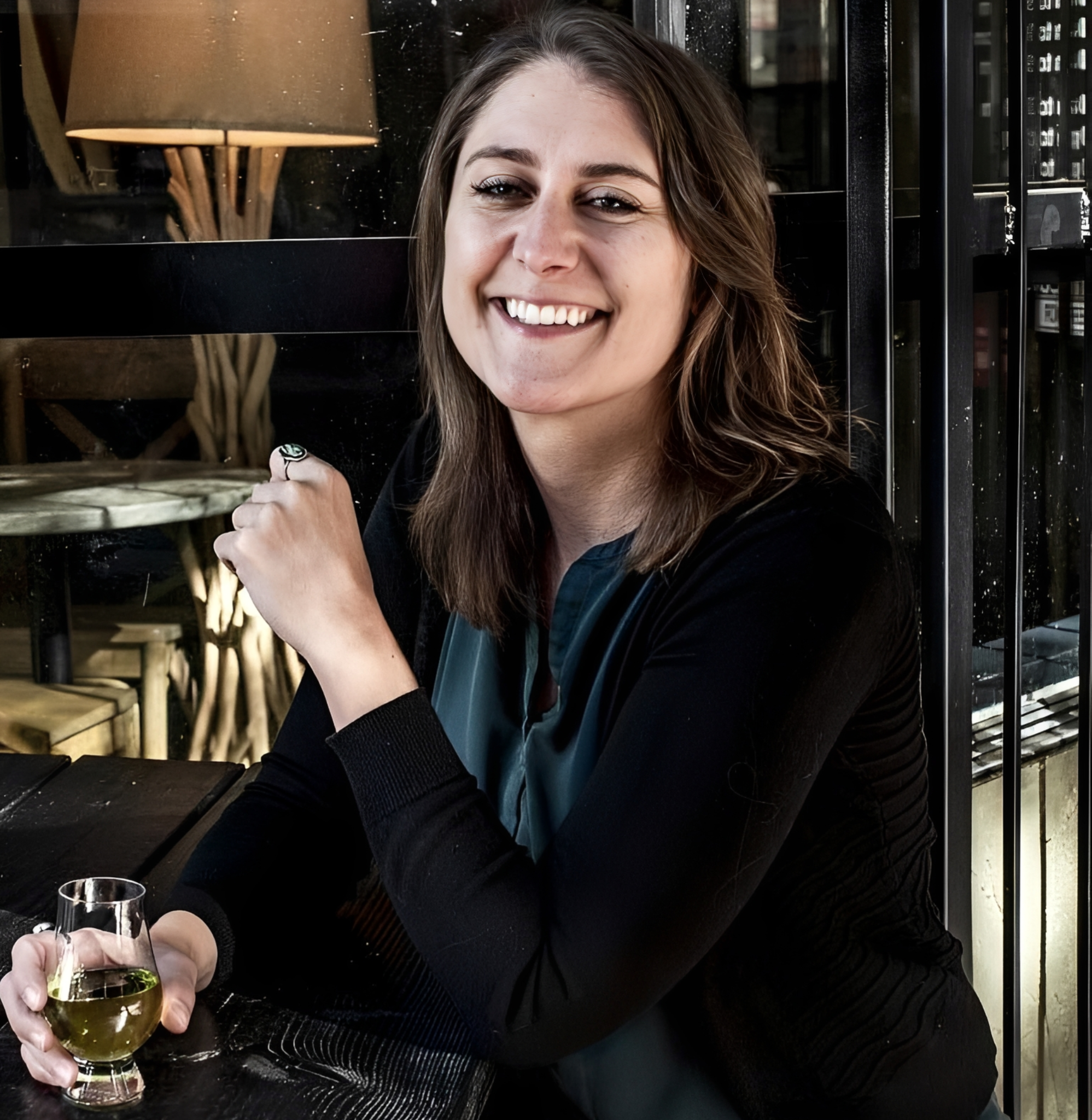 Smiling woman holding a drink indoors.
